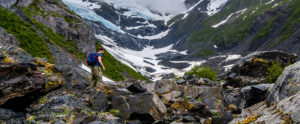 man backpacking up a mountain