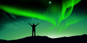Northern Lights with man on mountain